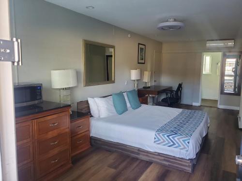 Dormitorio con cama, escritorio y TV en OMEO Suites Big Bear en Big Bear Lake