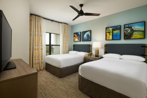 a hotel room with two beds and a flat screen tv at Sheraton Vistana Villages Resort Villas, I-Drive Orlando in Orlando