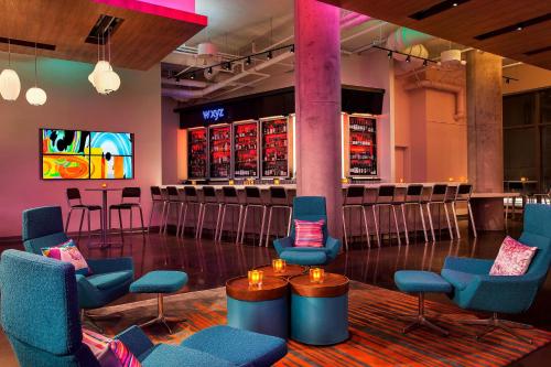 a bar in a room with chairs and a bar at Aloft Boston Seaport District in Boston