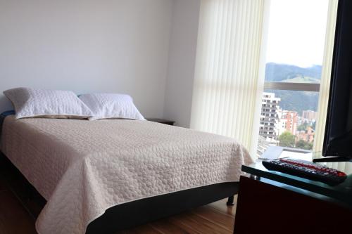 a bedroom with a bed with a window and a television at Suite La Colina - Norte - Pasto in Pasto