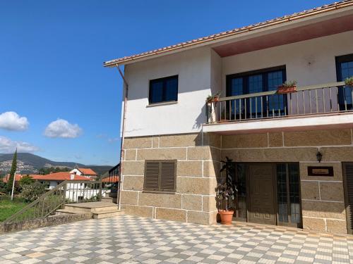 a building with a balcony and a patio at Casa Pedravedra in Mondim de Basto