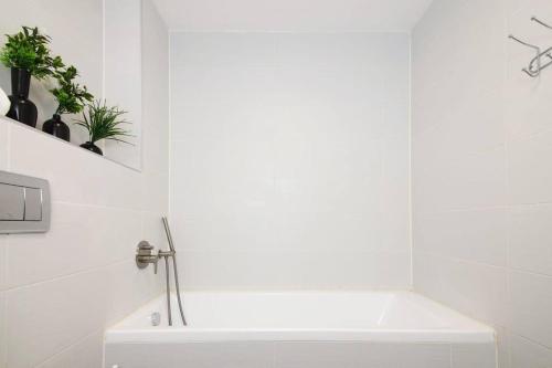 a white bathroom with a tub and a sink at Agrippas Suite 6 in Jerusalem
