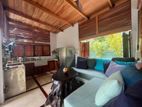 a living room with a couch and a kitchen at Private NEW beach house with garden in Cabuya