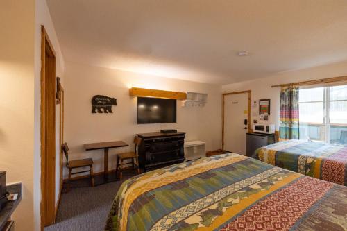 ein Hotelzimmer mit zwei Betten und einem Schreibtisch in der Unterkunft Elk Horn Lodge in Cooke City