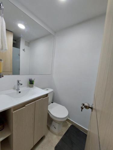 y baño con aseo blanco y lavamanos. en Splendid Loft in Chapinero en Bogotá