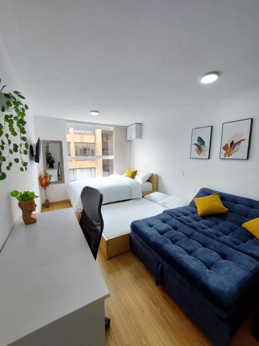 1 dormitorio con 2 camas y sofá azul en Splendid Loft in Chapinero en Bogotá