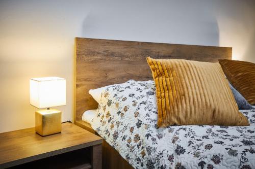 a bedroom with a bed with a wooden headboard and a lamp at Penzion Weber in Český Krumlov