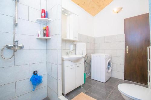 ein Badezimmer mit Waschbecken und Waschmaschine in der Unterkunft Family friendly house with a swimming pool Vadalj, Primosten - 21379 in Vadalj