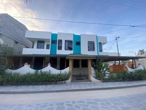 un bâtiment bleu et blanc avec dans l'établissement Hostal Brisas Del Mar, à Puerto Villamil