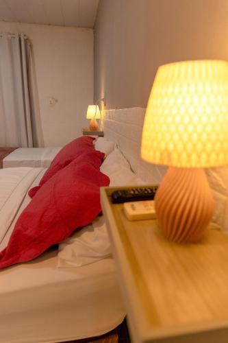 a bedroom with a bed and a table with a lamp at Noronha Economy Suítes - Hospedagem com melhor localização e custo benefício da ilha in Fernando de Noronha