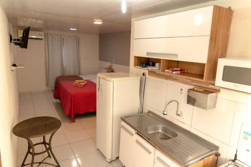 a small kitchen with a sink and a refrigerator at Noronha Economy Suítes - Hospedagem com melhor localização e custo benefício da ilha in Fernando de Noronha