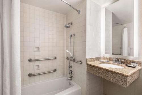 uma casa de banho com uma banheira, um lavatório e um chuveiro em Sheraton Raleigh Hotel em Raleigh