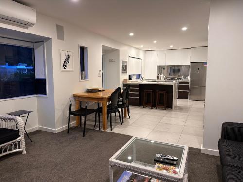 a living room with a table and a kitchen at The Bay The Beach The Mount The Best in Mount Maunganui