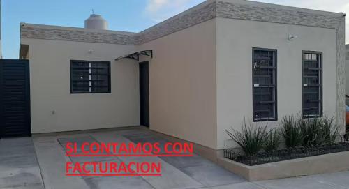 Une maison blanche avec un panneau rouge qui dit séminaires en fédération dans l'établissement Casa Mina la prieta, à Hidalgo del Parral