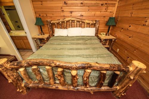 ピジョン・フォージにあるCabin Close to parkway rd with River Viewのログキャビン内のベッドルーム1室(ログベッド1台付)