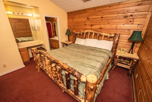 een slaapkamer met een bed met een houten muur bij Cabin Close to parkway rd with River View in Pigeon Forge
