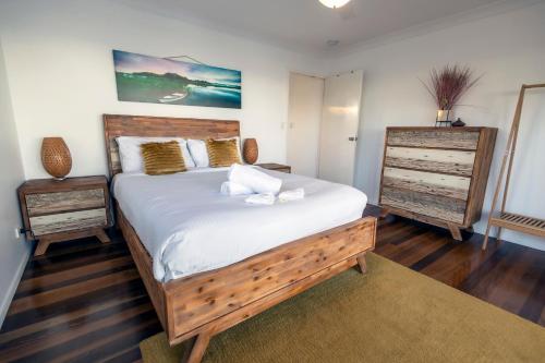 a bedroom with a large bed and a dresser at Happy Tides in Beachmere