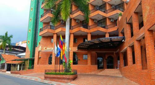 伊瓦格的住宿－莫拉萊斯國際酒店及會議中心，前面有两面旗帜的建筑