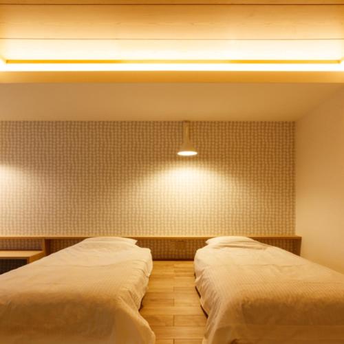 Giường trong phòng chung tại Umemura Ryokan Uguisutei