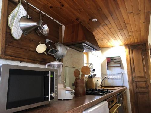 a kitchen with a microwave oven and a stove at Grande maison familiale, rustique et charmante en Bourgogne, dans le Morvan in Dun-sur-Grandry
