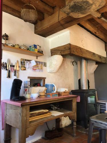 a kitchen with a wooden table and a stove at Grande maison familiale, rustique et charmante en Bourgogne, dans le Morvan in Dun-sur-Grandry