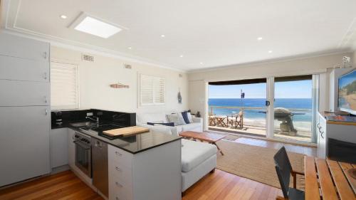 cocina y sala de estar con vistas al océano en On The Beach #13 Beachfront, Ocean Views Accom Holidays, en Wamberal