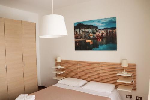 パレルモにあるAppartamenti-Residence Al Massimoのベッドルーム1室(ベッド1台付)が備わります。壁には絵画が飾られています。