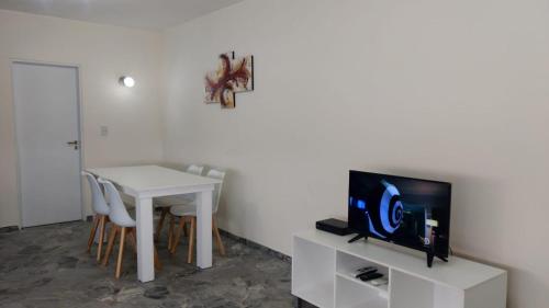sala de estar con mesa blanca y TV en DEPARTAMENTOS MENDOZA PEATONAL 2 en Mendoza