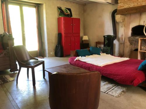 1 dormitorio con cama, silla y cómoda roja en Grande maison familiale, rustique et charmante en Bourgogne, dans le Morvan, en Dun-sur-Grandry