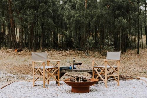two chairs and a table with a bottle of wine at Black Springs - A Romantic Bushland Escape in Mudgee