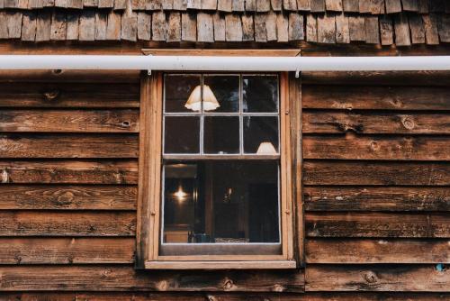 a window on the side of a wooden house at The Gully - Dreamy Cabin on Acres of Outback Charm in Mudgee