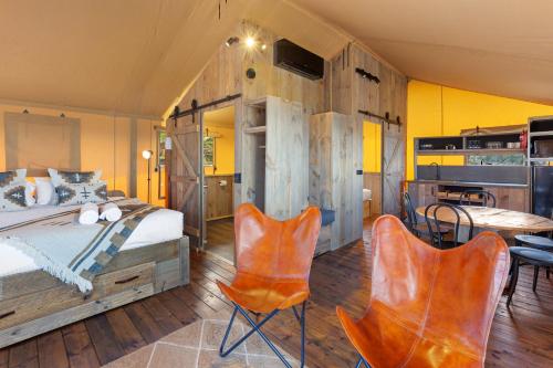 1 Schlafzimmer mit einem Bett, 2 Stühlen und einem Tisch in der Unterkunft BIG4 Apollo Bay Pisces Holiday Park in Apollo Bay