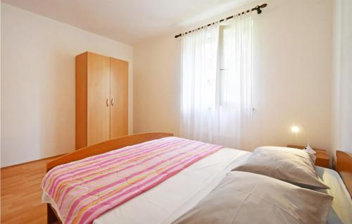 ein Schlafzimmer mit einem großen Bett und einem Fenster in der Unterkunft Cozy Apartment In Rabac With Kitchen in Rabac