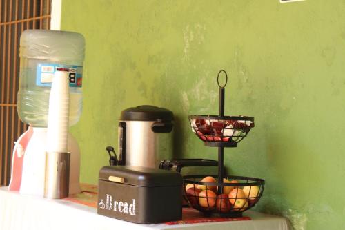 a coffee maker and a basket of fruit on a counter at Hotel Guaranducha Inn in Campeche