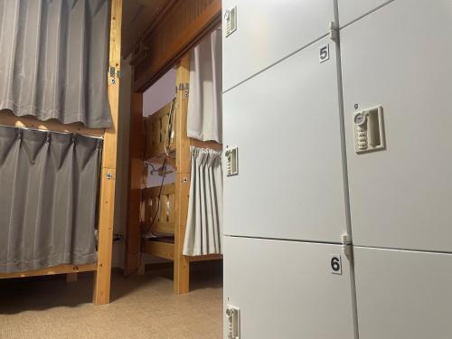 two white cabinets in a room with a closet at Shaq Bighouse in Kanazawa