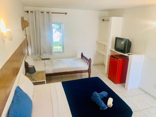 a small room with a bed and a tv at Suite familiar completa in Búzios