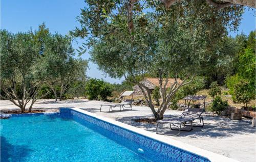 a swimming pool with chairs and trees in a yard at 2 Bedroom Lovely Home In Blato in Blato