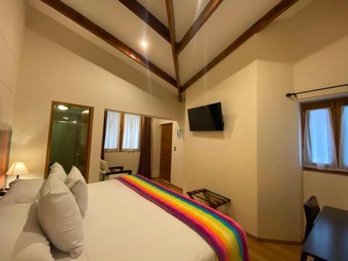 a bedroom with a rainbow blanket on a bed at Mistico San Blas Boutique in Cusco