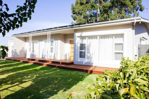 a white house with a porch and a yard at The Beech House-Hill views, peaceful location, 2BR in Tanunda