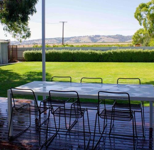 a white table with four chairs and a field at The Beech House-Hill views, peaceful location, 2BR in Tanunda