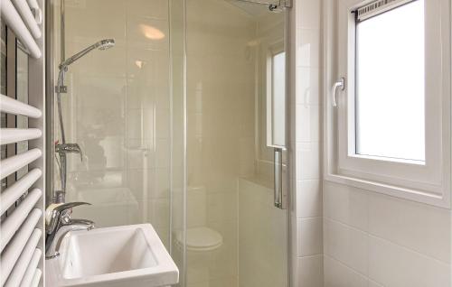een witte badkamer met een wastafel en een douche bij Gorgeous stacaravan In Julianadorp With House A Panoramic View in Julianadorp