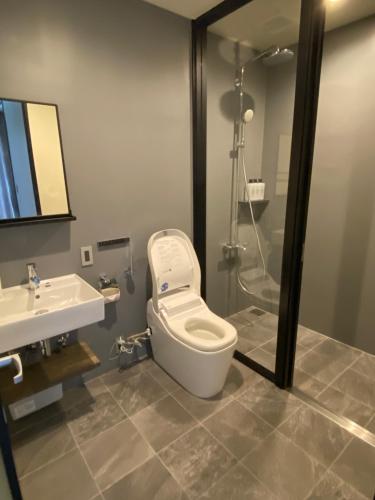 a bathroom with a toilet and a sink and a shower at Sky Blue Villa沖縄 in Jima