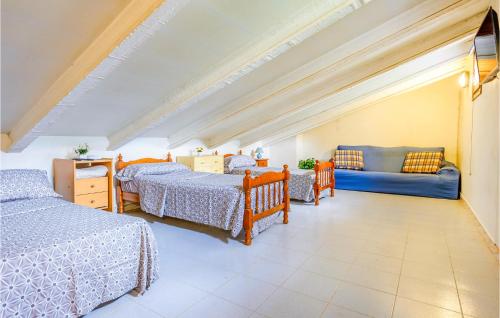 a bedroom with three beds and a couch at Gorgeous Home In Maanet De La Selva With Kitchen in Maçanet de la Selva