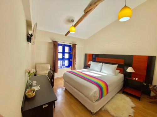 a bedroom with a large bed and a desk and a desk at Mistico San Blas Boutique in Cusco