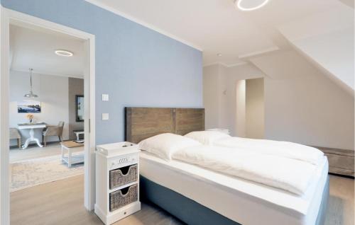 - une chambre avec un lit blanc et un mur bleu dans l'établissement Baltischer Hof Apartment 59, à Boltenhagen
