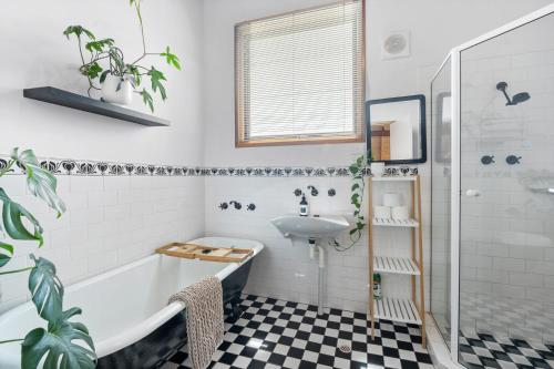 uma casa de banho com uma banheira e um lavatório em CHALET MOMA Port Elliot - BYO Linen - for lovers of different em Port Elliot
