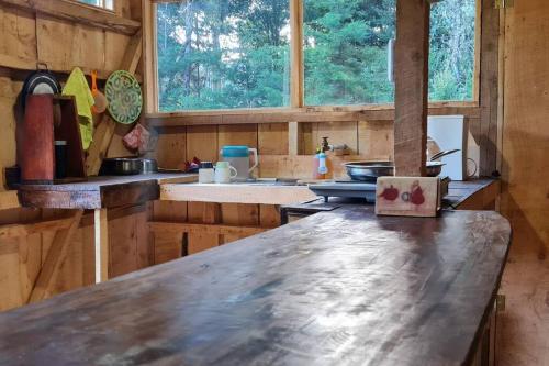 uma cozinha com um balcão de madeira num quarto em Cabaña El Descanso #1, Macho Mora Mountain Lodge em Alaska