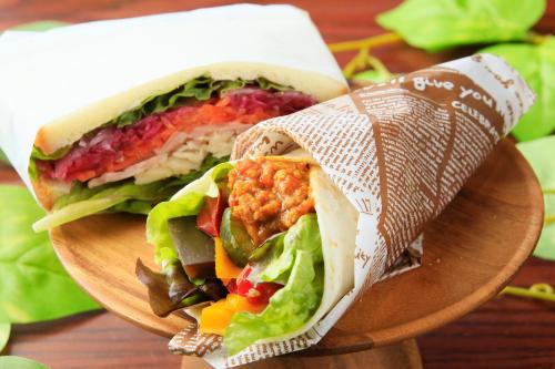 a sandwich cut in half on a wooden plate at QuintessaHotel FukuokaHakata Relax&Sleep in Fukuoka