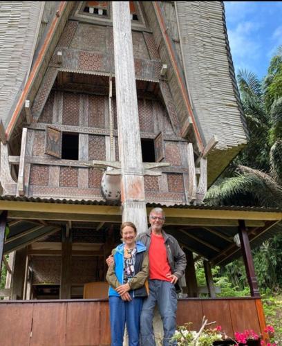 a man and a woman standing in front of a building at NUANSA HOMESTAY Authentic&Hospitality in Rantepao