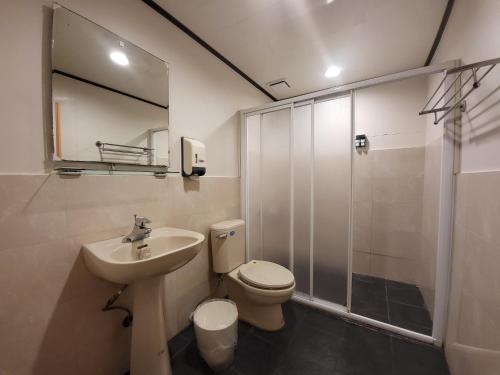 a bathroom with a toilet and a sink and a shower at 驛站會館 in Luodong